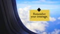 Life inspirational and motivational quote - Remember your courage. Sign on a plane\'s window with bright blue sky background. Royalty Free Stock Photo