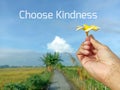 Life inspirational quote - Choose kindness. With person holding Bali frangipany flower against blue sky. Royalty Free Stock Photo