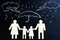Life insurance. Drawn rain and family figures under umbrella