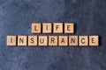 `Life Insurance` spelled out in wooden letter tiles