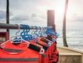 Life jackets dry on hangers at a beach, selective focus Royalty Free Stock Photo