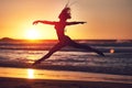 Life without liberty is like a body without a soul. Silhouette of an energetic woman jumping on the beach at sunset. Royalty Free Stock Photo