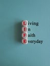 LIFE living in faith everyday symbol. Concept red words LIFE living in faith everyday on wooden cubes on blue backgroun Royalty Free Stock Photo