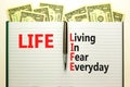 LIFE living in fear everyday symbol. Concept words LIFE living in fear everyday on book on beautiful white background. Dollar Royalty Free Stock Photo