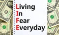 LIFE living in fear everyday symbol. Concept words LIFE living in fear everyday on note on beautiful white background. Dollar Royalty Free Stock Photo