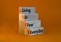 LIFE living in fear everyday symbol. Concept words LIFE living in fear everyday on wooden blocks on beautiful orange table orange Royalty Free Stock Photo