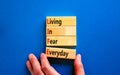 LIFE living in fear everyday symbol. Concept words LIFE living in fear everyday on wooden blocks on an blue background. Royalty Free Stock Photo