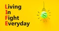 LIFE living in fight everyday symbol. Concept words LIFE living in fight everyday on yellow background. Green light bulb icon.