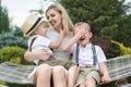 Life moment of happy family!Young mother and two beautiful sons ride on the swings