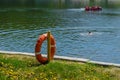 Life preserver on the shore of the lake in the background swimming people Royalty Free Stock Photo