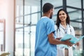 Life saving experts. two young doctors discussing the contents of a file in a modern hospital.