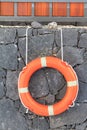 Life saving ring mounted on a lava wall Royalty Free Stock Photo