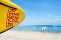 Life saving yellow board with surf rescue sign on beach