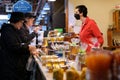 Granville Island different products shopping woman selling honey wax all about bees she has customers signboard yellow