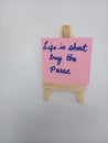 Life is short buy the purse sign on a wood easel on a white background