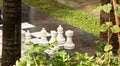 Life size outdoor chess pieces stand at the ready among tropical foliage and palms.