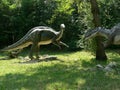 Predator dinosaur lurking to attack an iguanodon in the wood of the Extinction Park in Italy