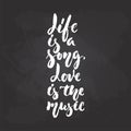 Life is a song. Love is the music - hand drawn Musical lettering phrase isolated on the black chalkboard background. Fun