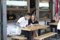 Life of street cafe. Man and woman sitting at a table at an outdoor menu, choosing food Royalty Free Stock Photo