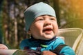 Life style close-up portrait baby boy little sits in a stroller and smiles, sunny day