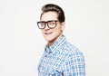 Portrait of a smart young man wearing eyeglasses standing against white background Royalty Free Stock Photo