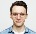 Portrait of a smart young man wearing eyeglasses standing against white background Royalty Free Stock Photo