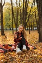 Life Style Portrait of Happy Woman in fall park. Beautiful girl on the nature picnic camping. Relaxing Girl in autumn Nature.