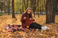 Life Style Portrait of Happy Woman in fall park. Beautiful girl on the nature picnic camping. Relaxing Girl in autumn Nature.