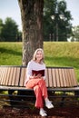 Woman with book sitting on bench under tree Royalty Free Stock Photo