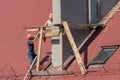 Life-threatening high-altitude work. A team of roofers works on the roof without insurance. Repair of the roof and ventilation Royalty Free Stock Photo