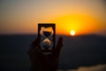 Life time passing concept. Hand holding hourglass with sunset sky background. Royalty Free Stock Photo