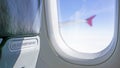 Life vest under your seat is the warning word on the seat backrest in airplane cabin beside glass window through the aircraft wing