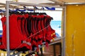Life vests hanging on a rack. Red lifejackets for watersport activity