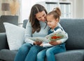 Life is what you make of it. a young mother reading to her daughter. Royalty Free Stock Photo