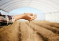 From this life will grow. a farmer letting dirt pour through her fingers.