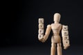 Life work balance concept. Wooden mannequin holding cubes on black background, space for text Royalty Free Stock Photo