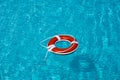 Lifebelt on sea or pool. Orange inflatable ring floating in blue water. Life buoy for protect and safety drowning. Royalty Free Stock Photo