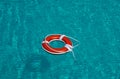 Lifebelt on sea or pool. Orange inflatable ring floating in blue water. Life buoy for protect and safety drowning. Royalty Free Stock Photo