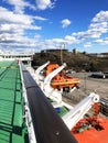 Lifeboats, decks and cabins on the side of cruiseship. Wing of running bridge of cruise liner. White cruise ship on a blue sky wit Royalty Free Stock Photo