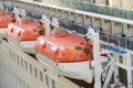 orange Lifeboats hanging over deck on cruise ship Royalty Free Stock Photo