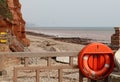 A lifebouy at the eastern end of Sidmouth Esplanade looking over the River Sid and on towards the East beach. This beach is now Royalty Free Stock Photo