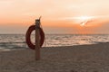 Lifebuoy on the background of the sea during the beach season summer vacation on the sunset. Royalty Free Stock Photo