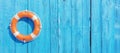 Lifebuoy on blue wood. Orange color life buoy ring, marine and swimming safety Royalty Free Stock Photo