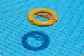 Lifebuoy floating on top of sunny blue water in swimming pool Royalty Free Stock Photo