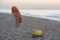 lifebuoy hanging on a wooden pole on the beach and the backdrop of sea at sunset. Saving life concept. Royalty Free Stock Photo