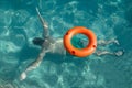 Lifebuoy on water and man diving under it. Lifeguard and drowning concepts