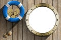 Lifebuoy and Metal Porthole on wooden wall Royalty Free Stock Photo