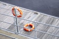 Lifebuoy orange ring on sea pontoon for water safety at marina