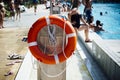 Lifebuoy on post in public swimming pool in summer