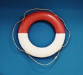 Lifebuoy red and white, on the blue wall background Royalty Free Stock Photo